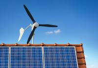 small windmill for small-scale wind energy above a house. Solar panels also atop roof.