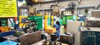 A woman works at a common facility center surrounded by machines