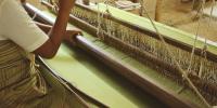 Woman weaves on a loom 