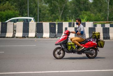 Delivery worker on a bike in the heat in Delhi