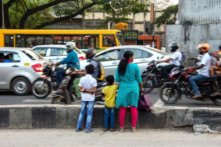 A family waits at a crossing line with no median gap at Tumkur Road in Bengaluru.