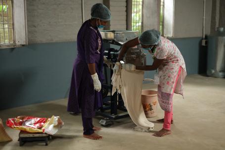 Farmer producer company (FPC) members using a millet processing machine in Deoghar, Jharkhand