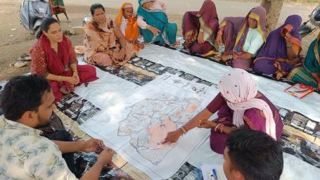 A self-help group member explains the process of GIS-enabled identification and planning of water resource management structures in her village.