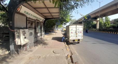 Delivery worker waits while charging EV Delhi