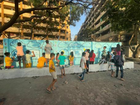 Children painting the wall at Lallubhai Compound