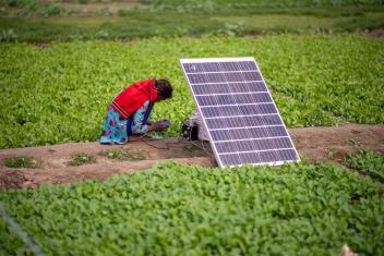 A girl charges her smart phone using solar energy. Photo by Pradeep Gaurs/Shutterstock