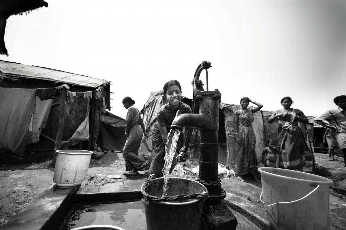 Women at communal handpump collecting water