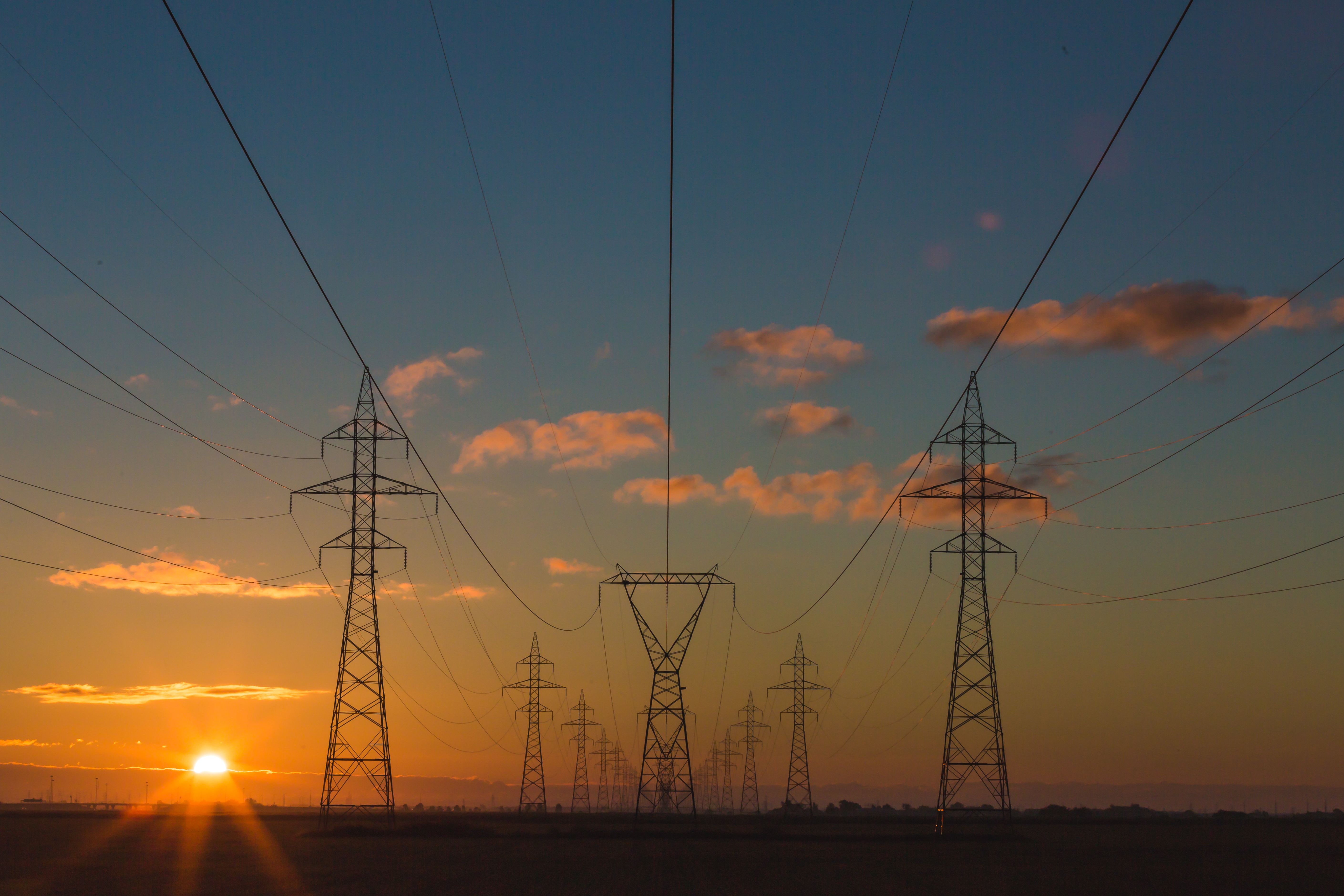 A row of pylons against a sunset orange sky.